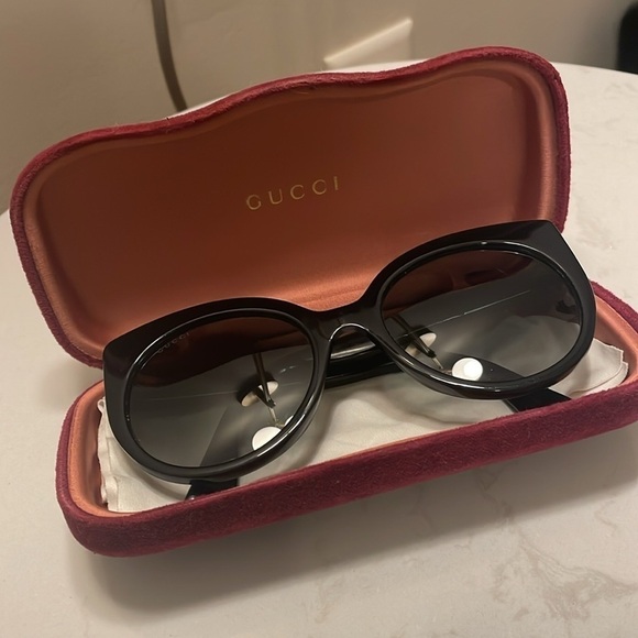 Gucci Cat Eye Black Sunglasses with golden logo temples and a logo on a lense